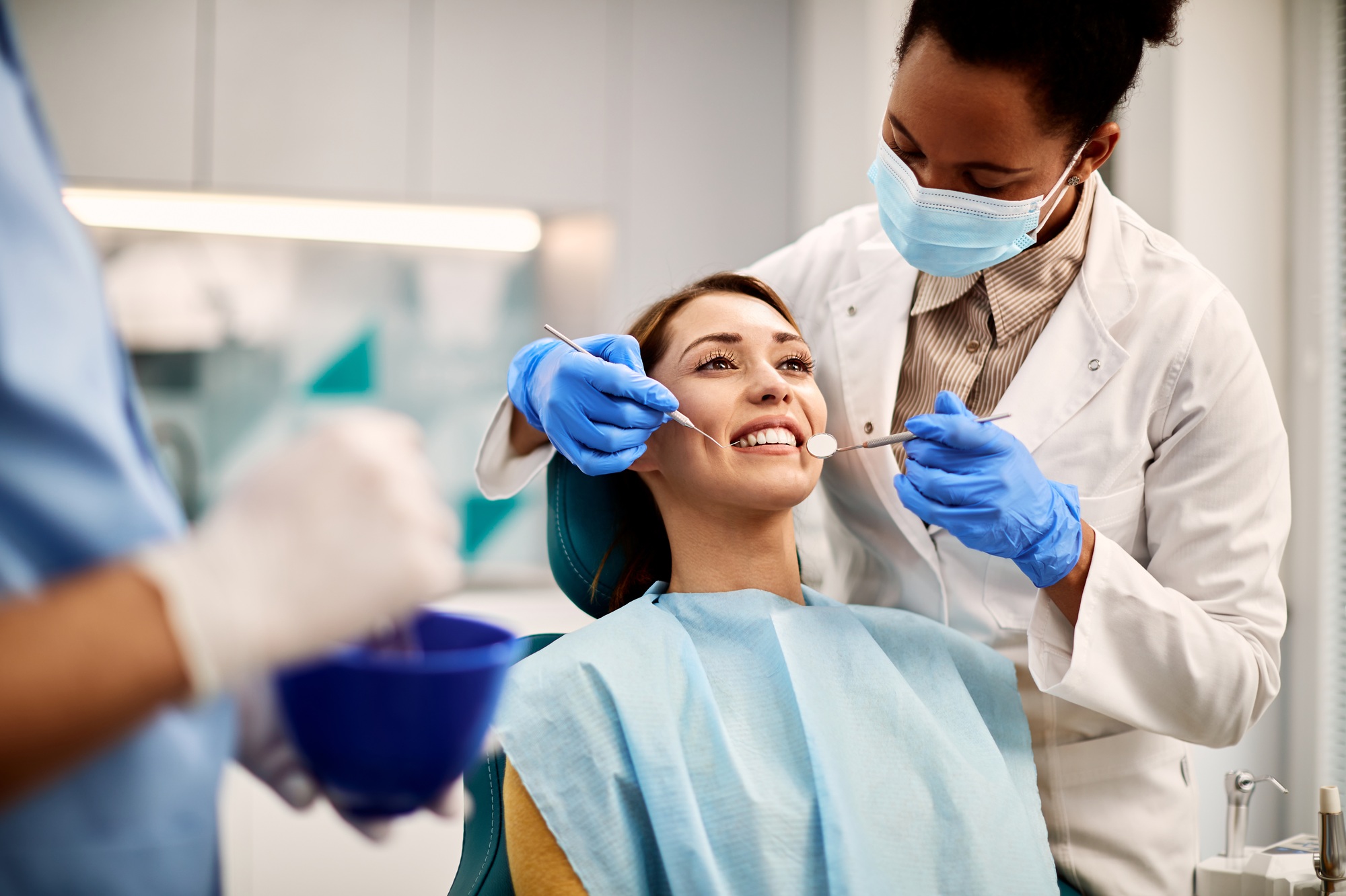 Young smiling woman having dental exam at dentist's office.